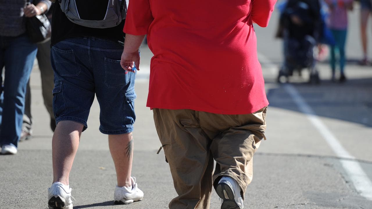 An overweight man walks through Brisbane
