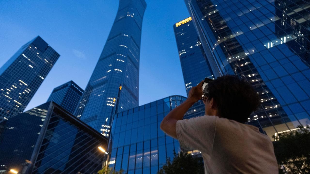 A passer-by takes photo of the damage on the Citic Tower in Beijing
