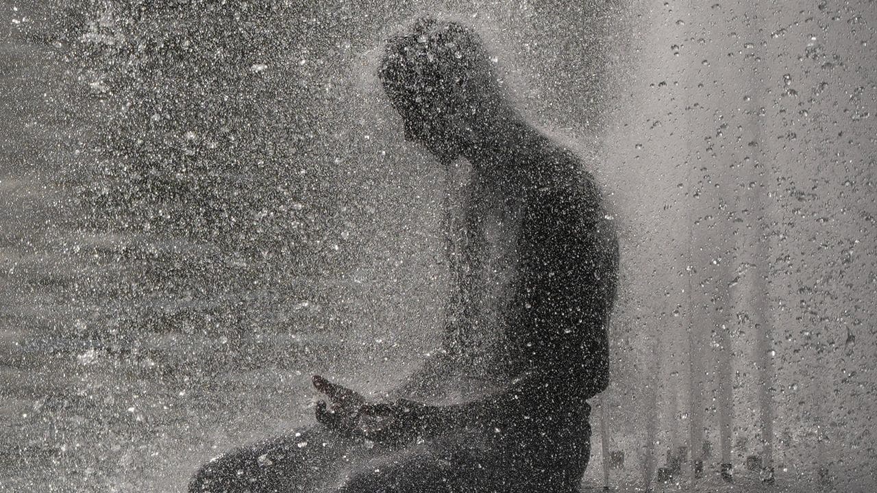 A person cools off at Trocadero fountain near the Eiffel Tower