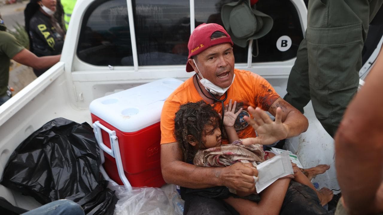 A rescuer carries a girl pulled from earthquake rubble in Venezuela