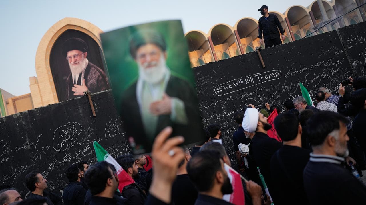 A mourner holds a portrait of Ayatollah Ali Khamenei