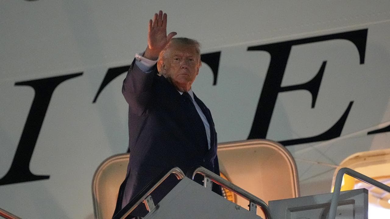 President Donald Trump waves as he boards Air Force One