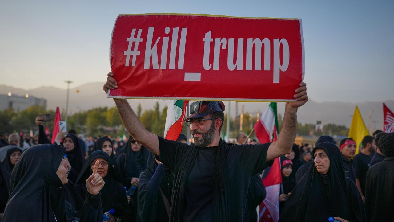 A man holds a sign reading 