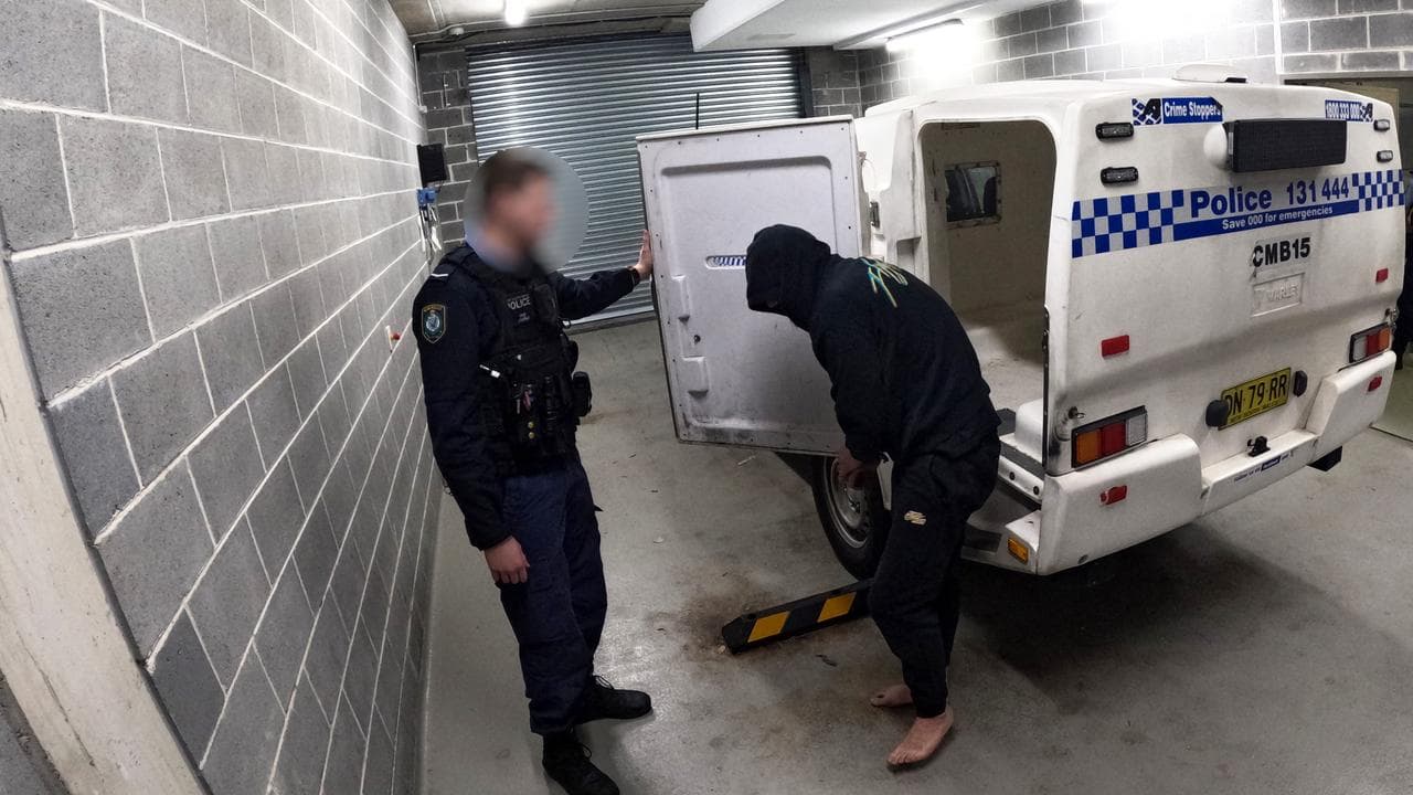 man in handcuffs exits police divvy van 