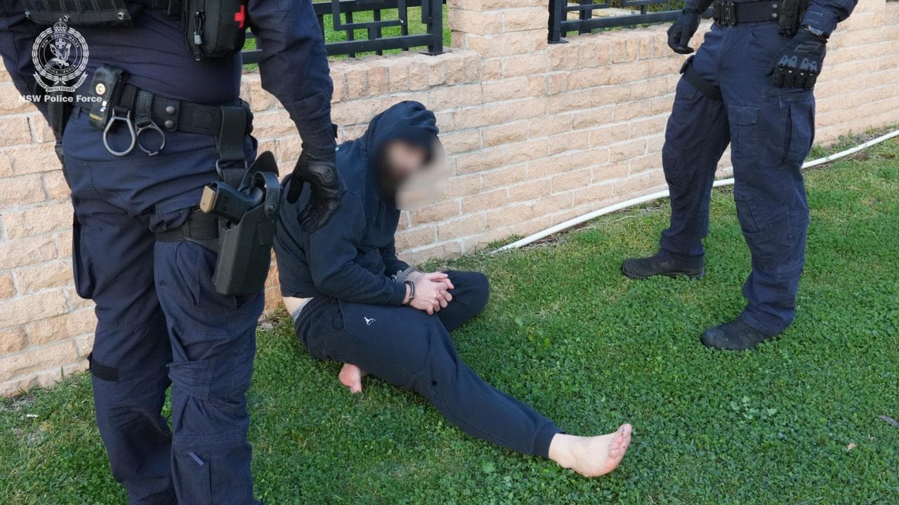 man in handcuffs seated alongside two police officers