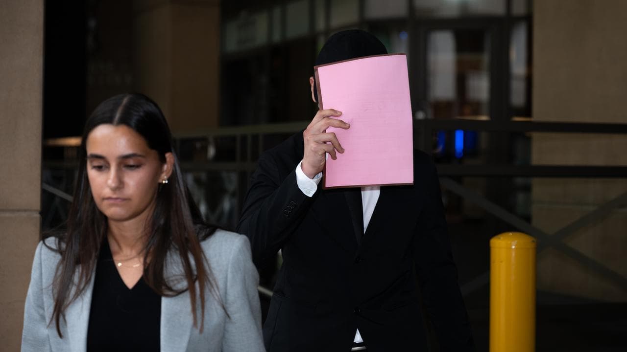 Ryan Cho holds an A4 folder in front of his face