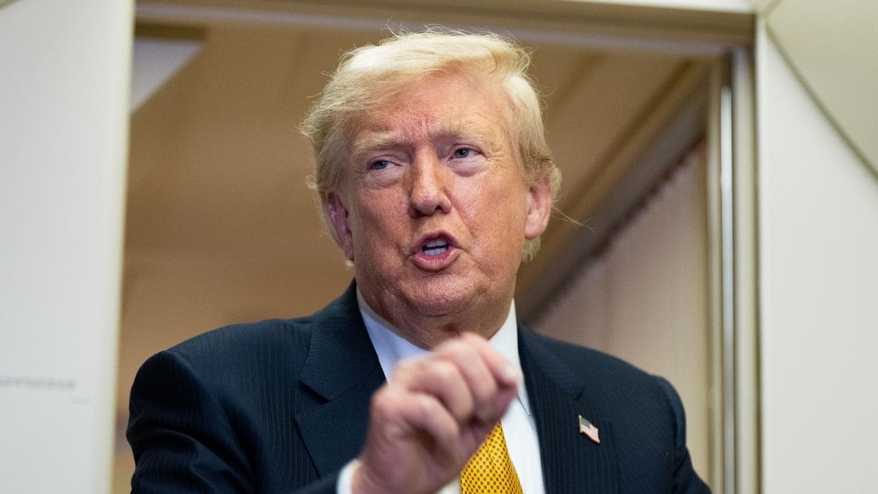 US President Donald Trump speaks with reporters on Air Force One