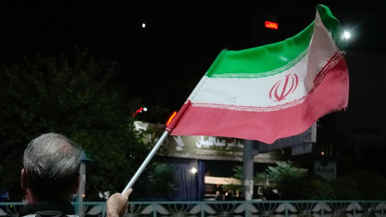 A pro-government demonstrator waves an Iranian flag in Tehran