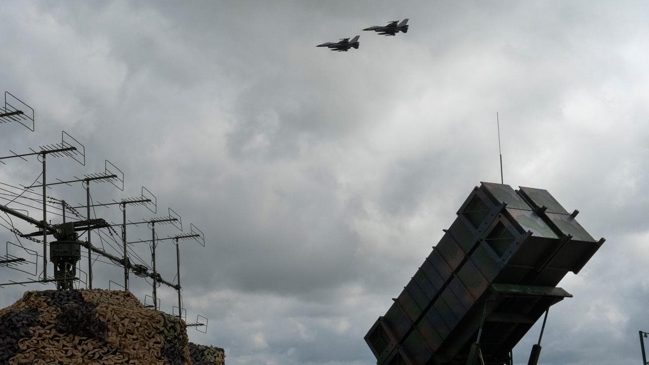 Ukrainian Air Force's F-16 jets fly over a Patriot defence system