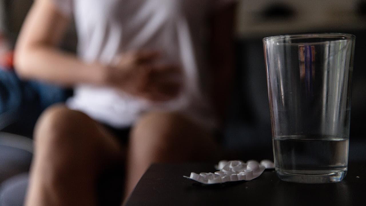 A woman holds her stomoach (file image)