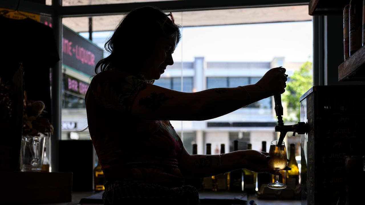 A worker pours a drink