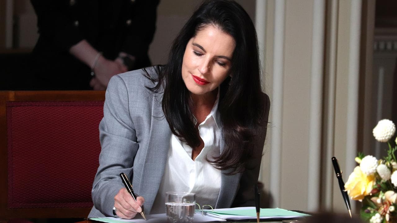 Jane Howlett signs documents during her swearing in