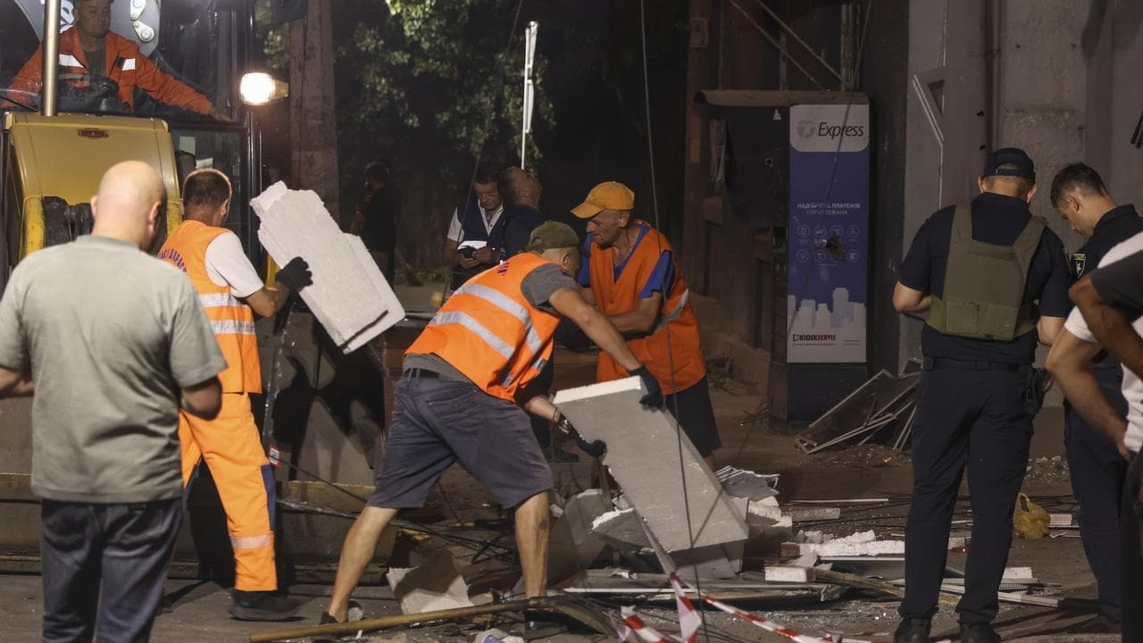 Workers clean debris after a Russian strike in Odesa, Ukraine