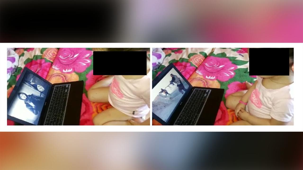 a child in front of a laptop which shows people with guns