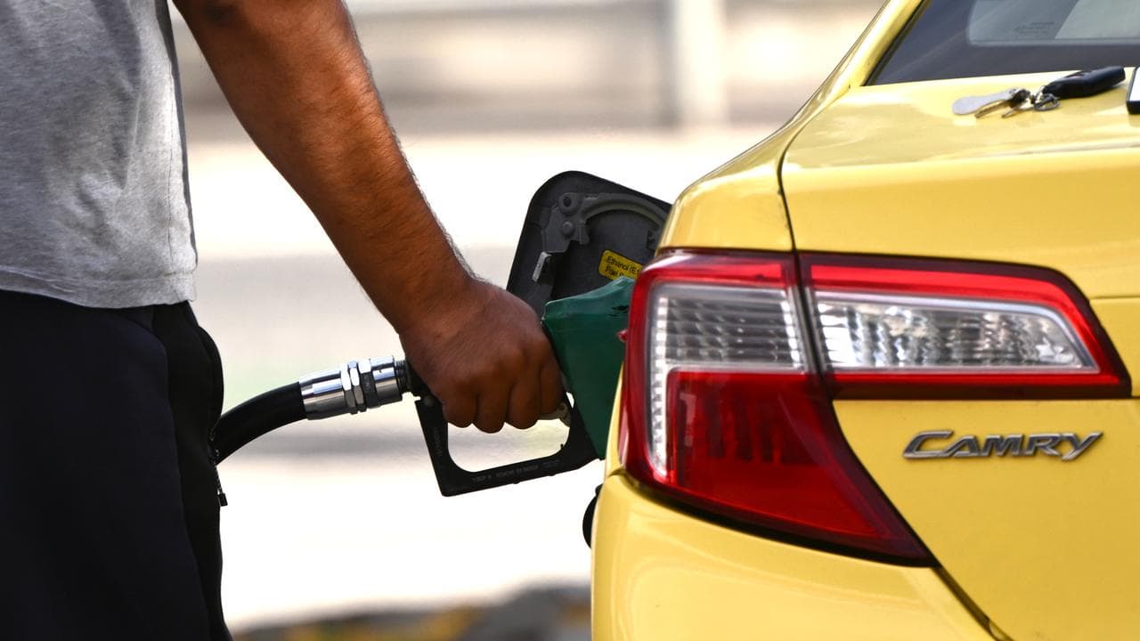 A customer uses a fuel pump to fill up a car (file image)