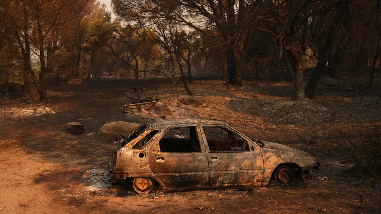 A car burned by a wildfire sits in Piedralaves, Avila province, Spain