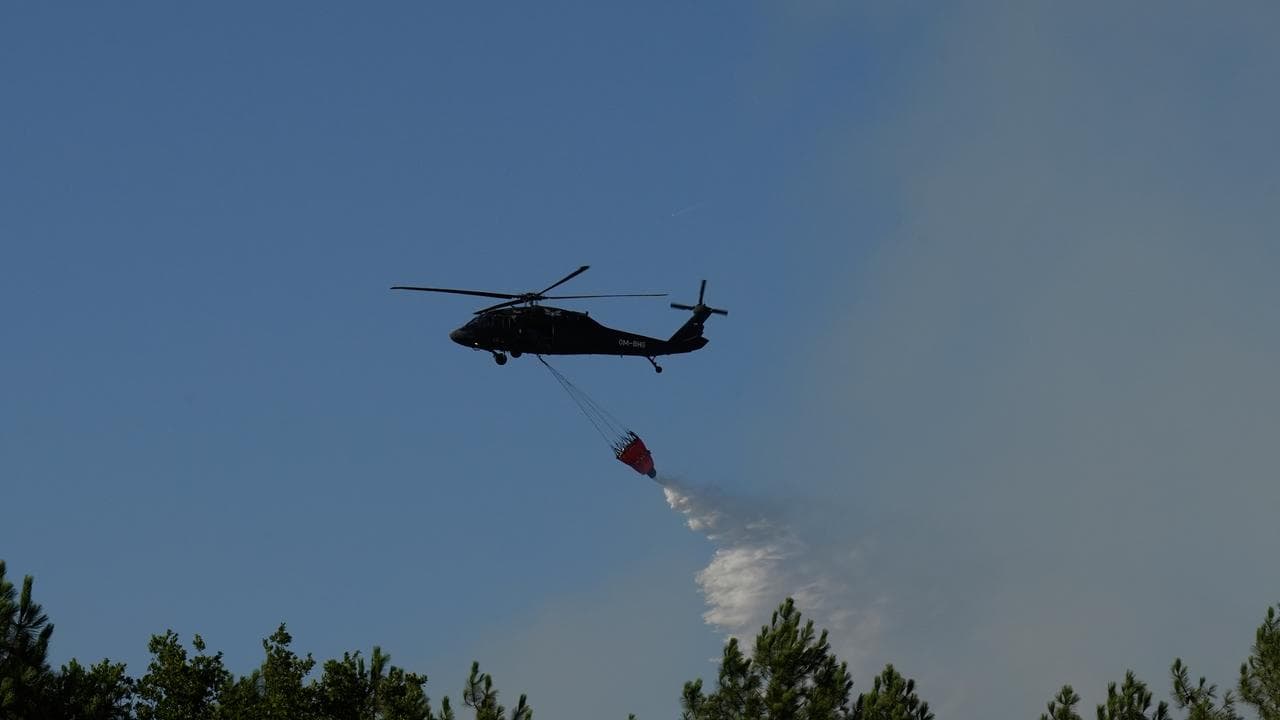 A Blackhawk helicopter drops water on a firezone near Bordeaux