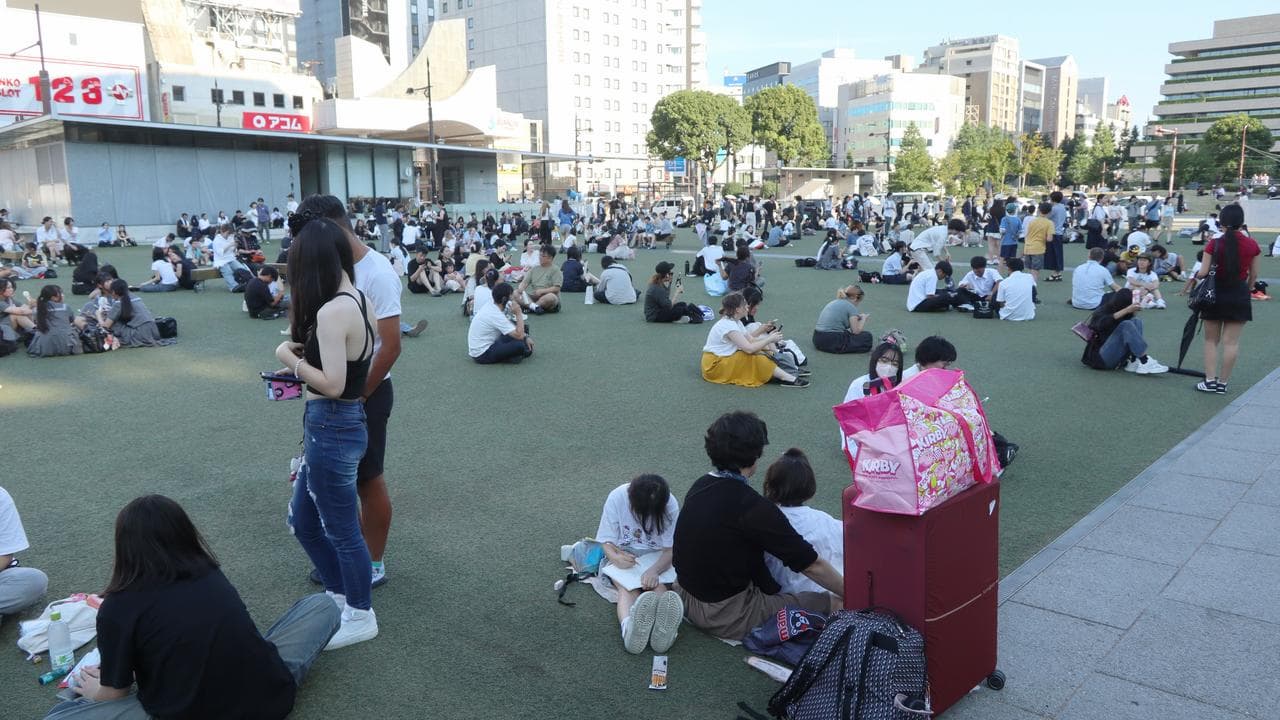 People gather outside following a powerful earthquake in Kumamoto City