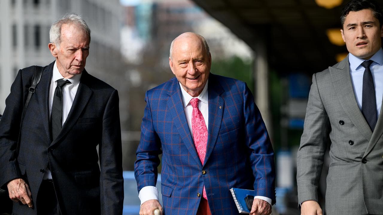 Alan Jones flanked by lawyers