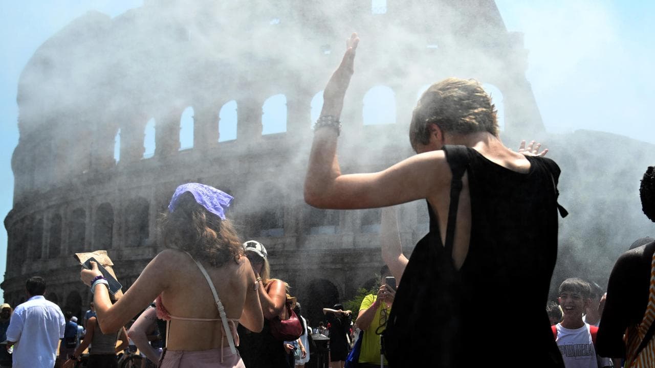 Tourists refresh with a water cannon in Rome