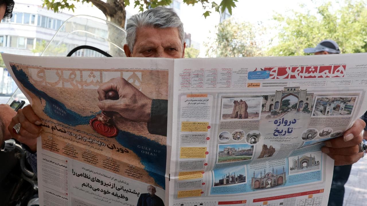 Man reads a newspaper in Tehran