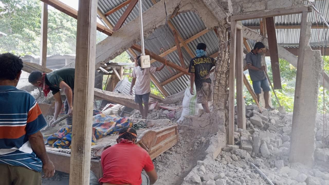 People clear up rubble after an earthquake in East Manggara, Indonesia
