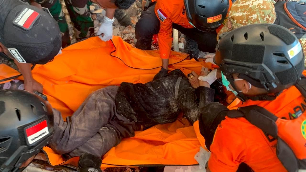 Rescuers move a victim after an earthquake in Maumere, Indonesia