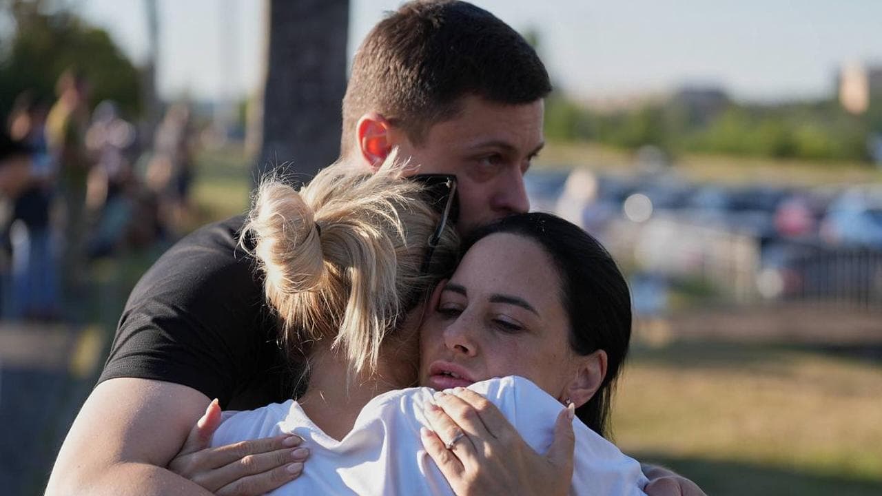 People embrace near a mall after a Russian attack in Kryvyi Rih