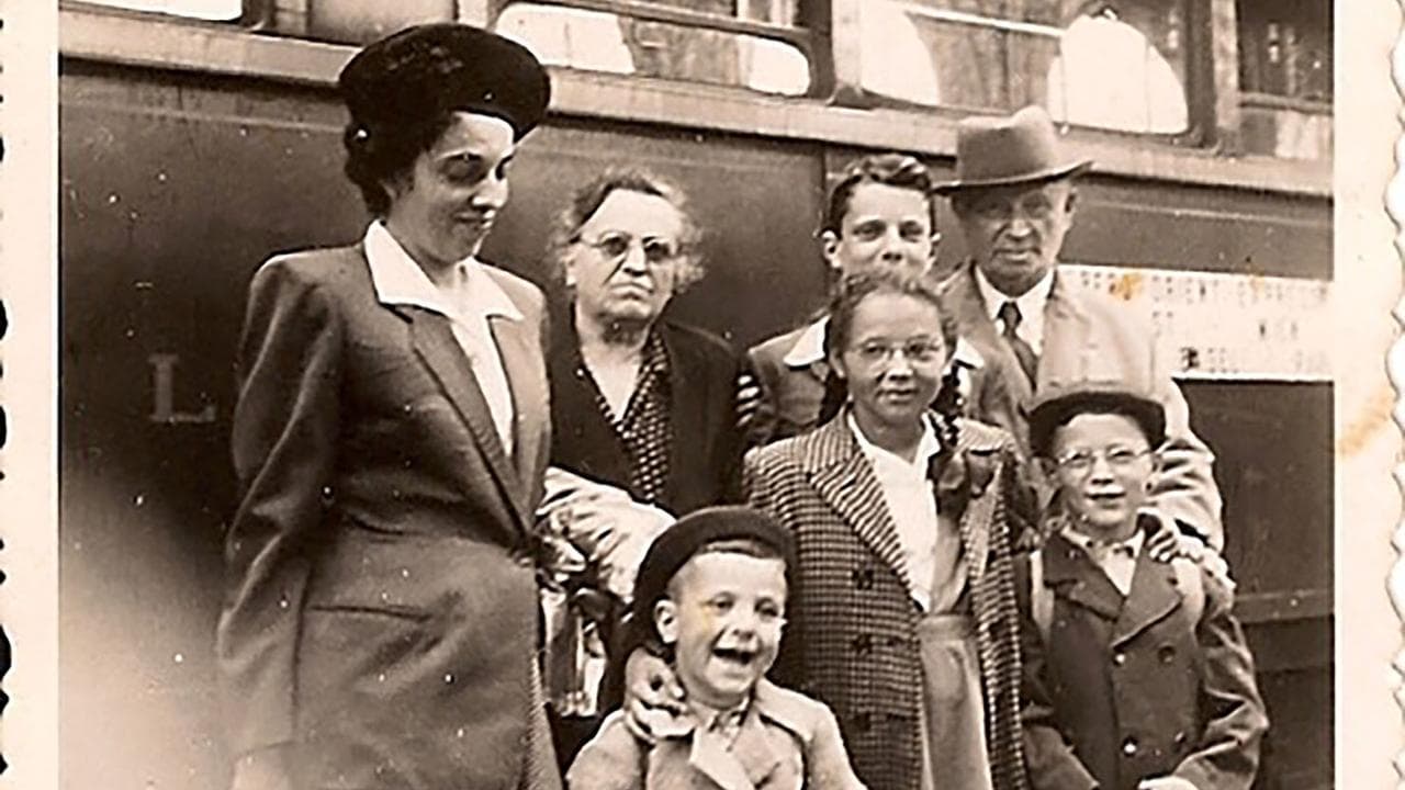 Peter Kraus standing next to a train with his family.