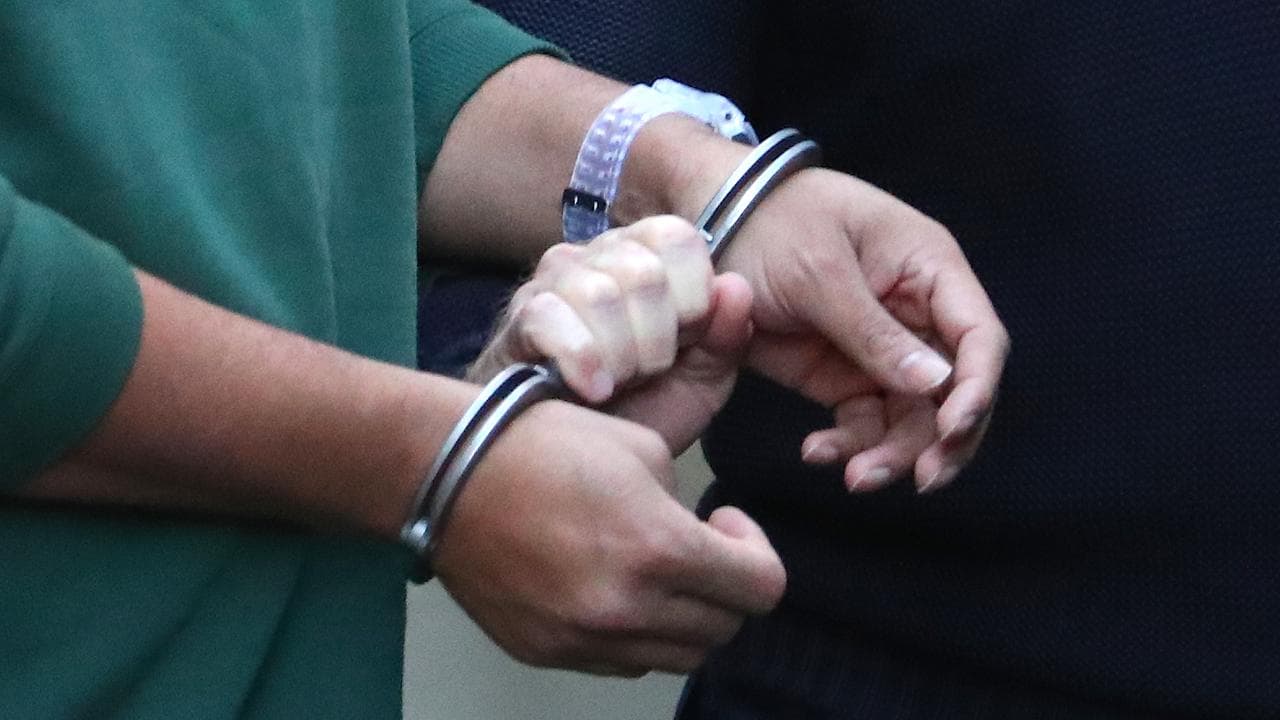 A prisoner is led by handcuffs from court (file image)