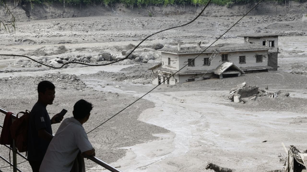 People watch floodwaters sweeping through Trishuli Bazar in Nepal