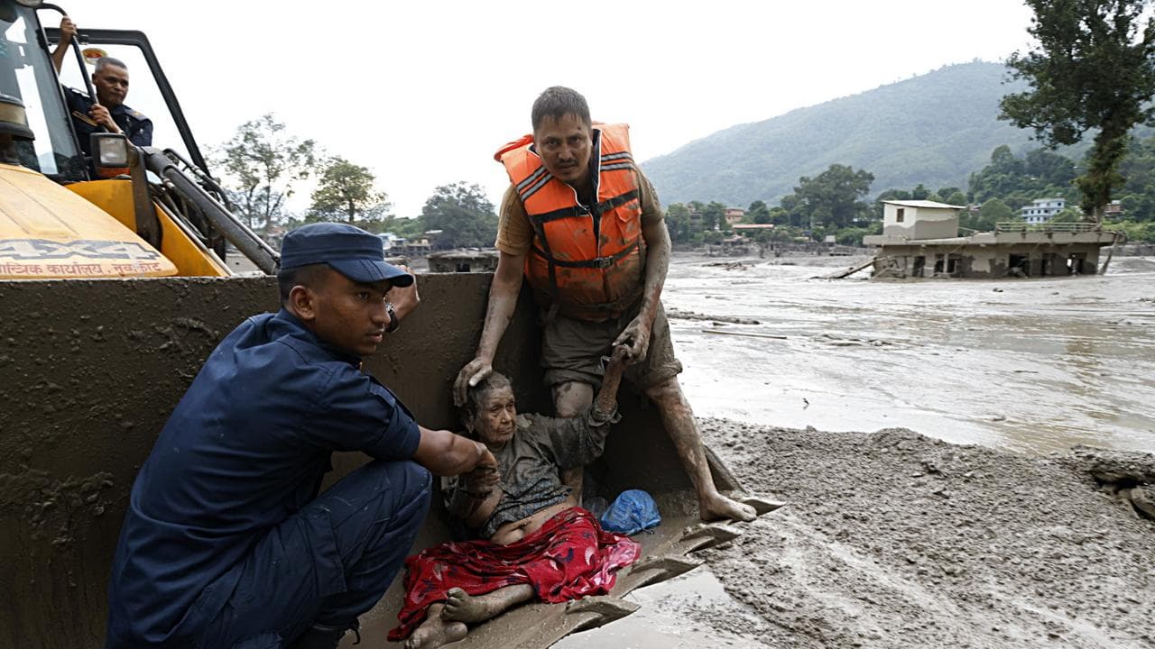 Rescuers transport an elderly woman rescued from floods