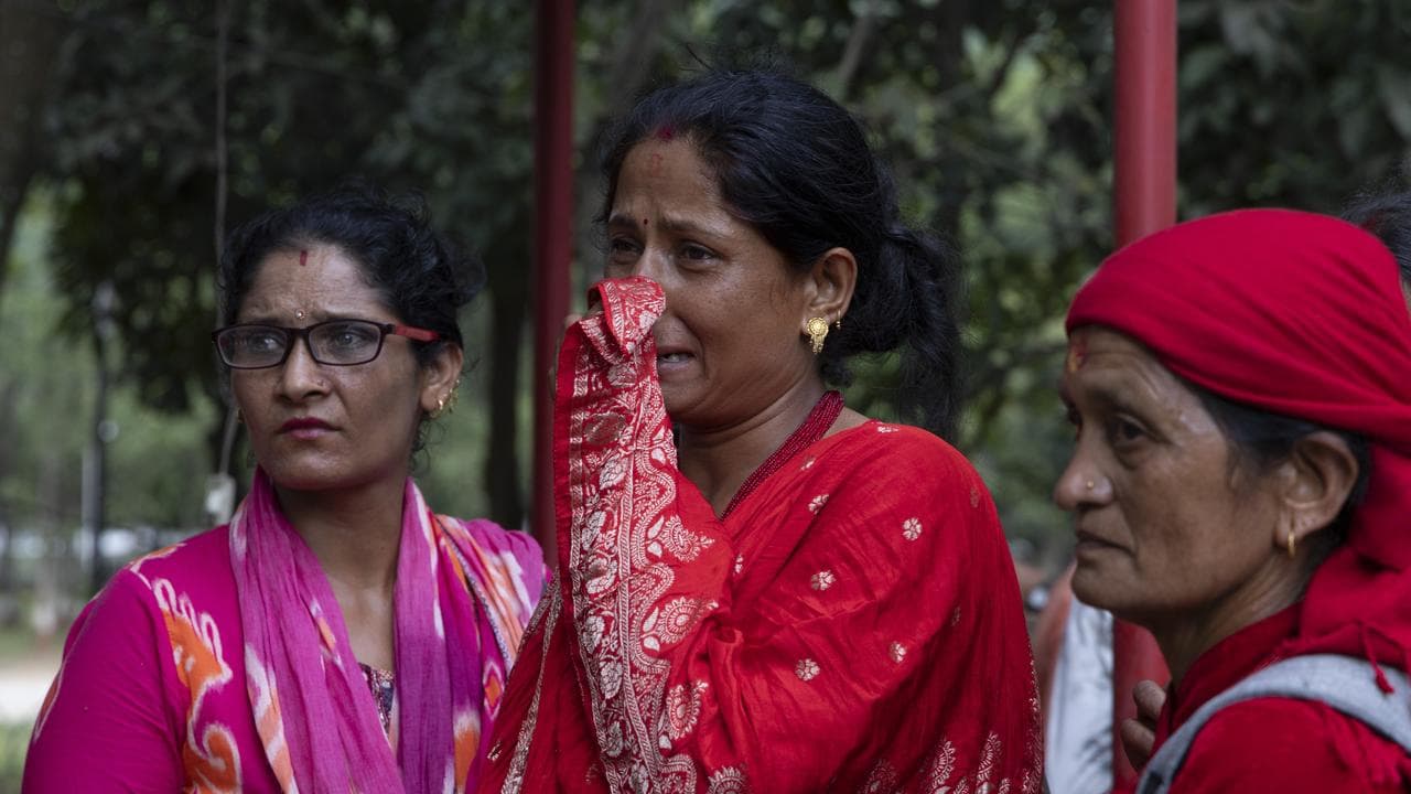 Local people gather outside a hospital following a flash flood