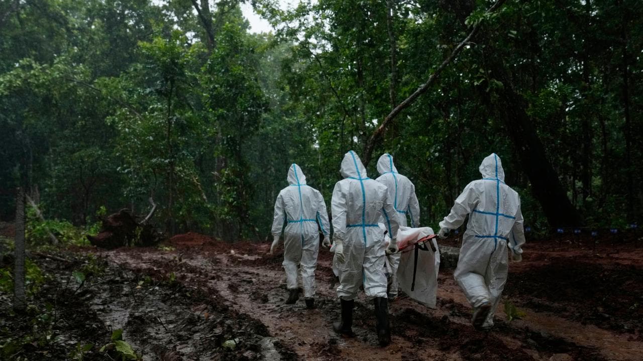 A flood victim is carried for burial at a mass burial site