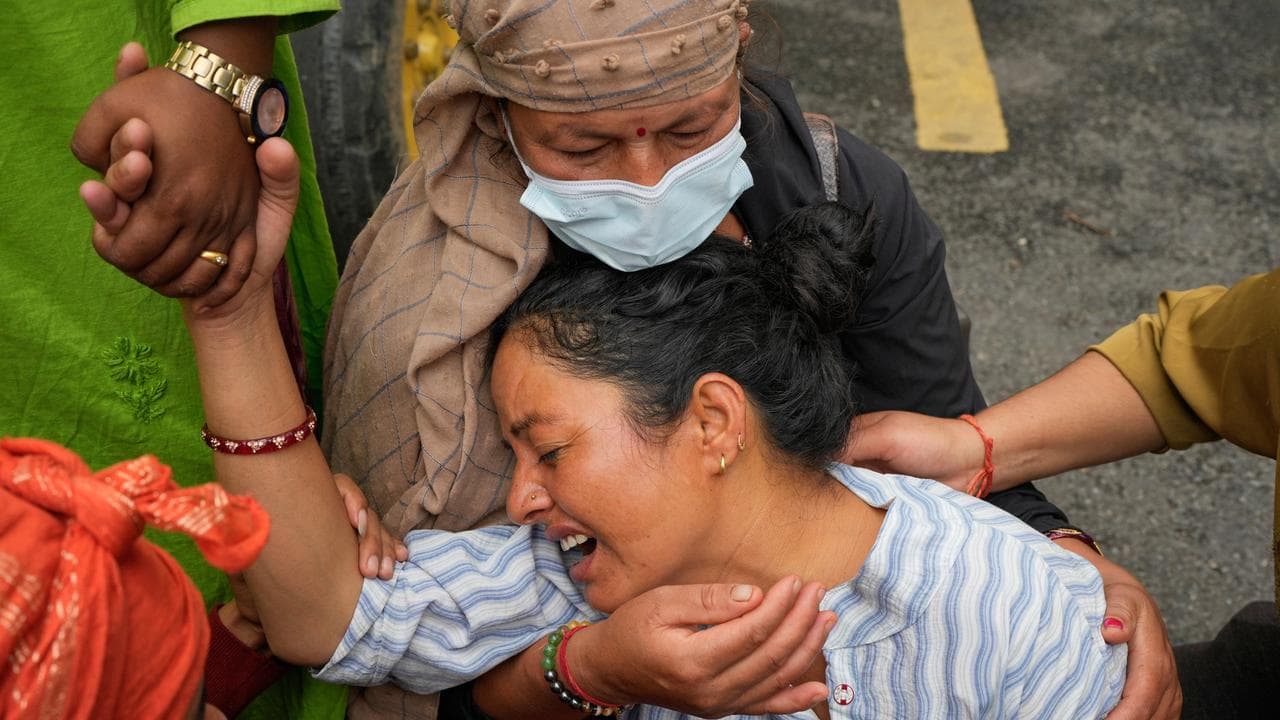 Relatives console Muna Khadka, center, who lost her son