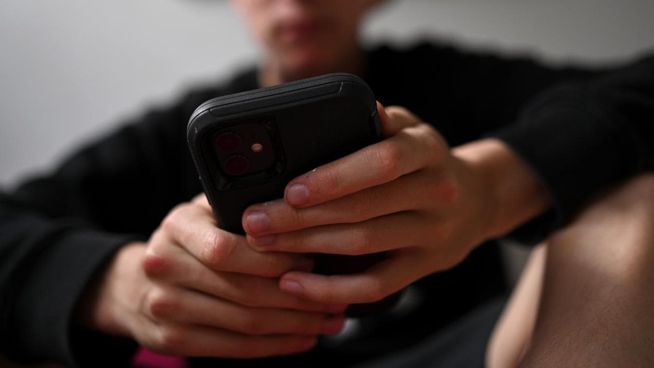 A teenager uses his mobile phone to access social media (file image)