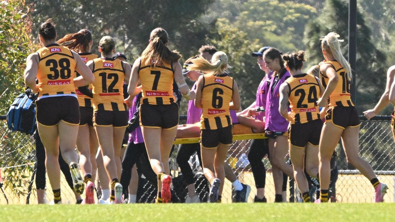 Teammates gathered around Hawthorn's Emily Bates.