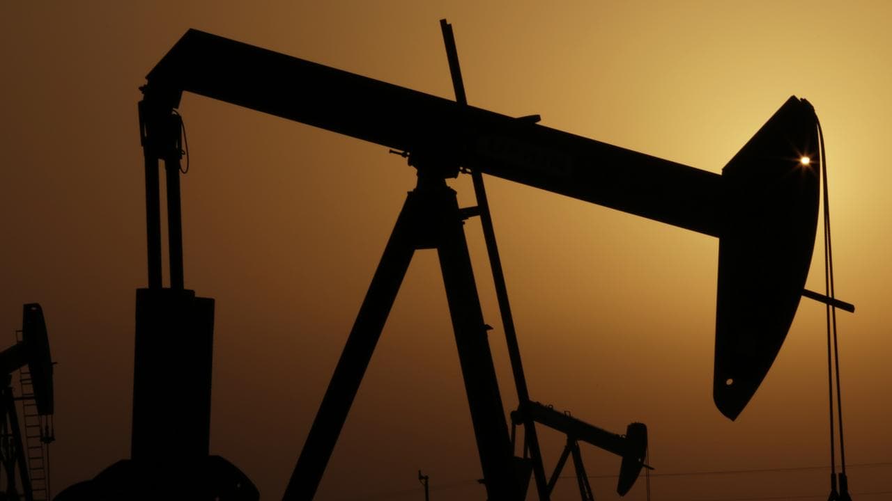 oil pumps work at sunset in the desert oil fields of Sakhir, Bahrain