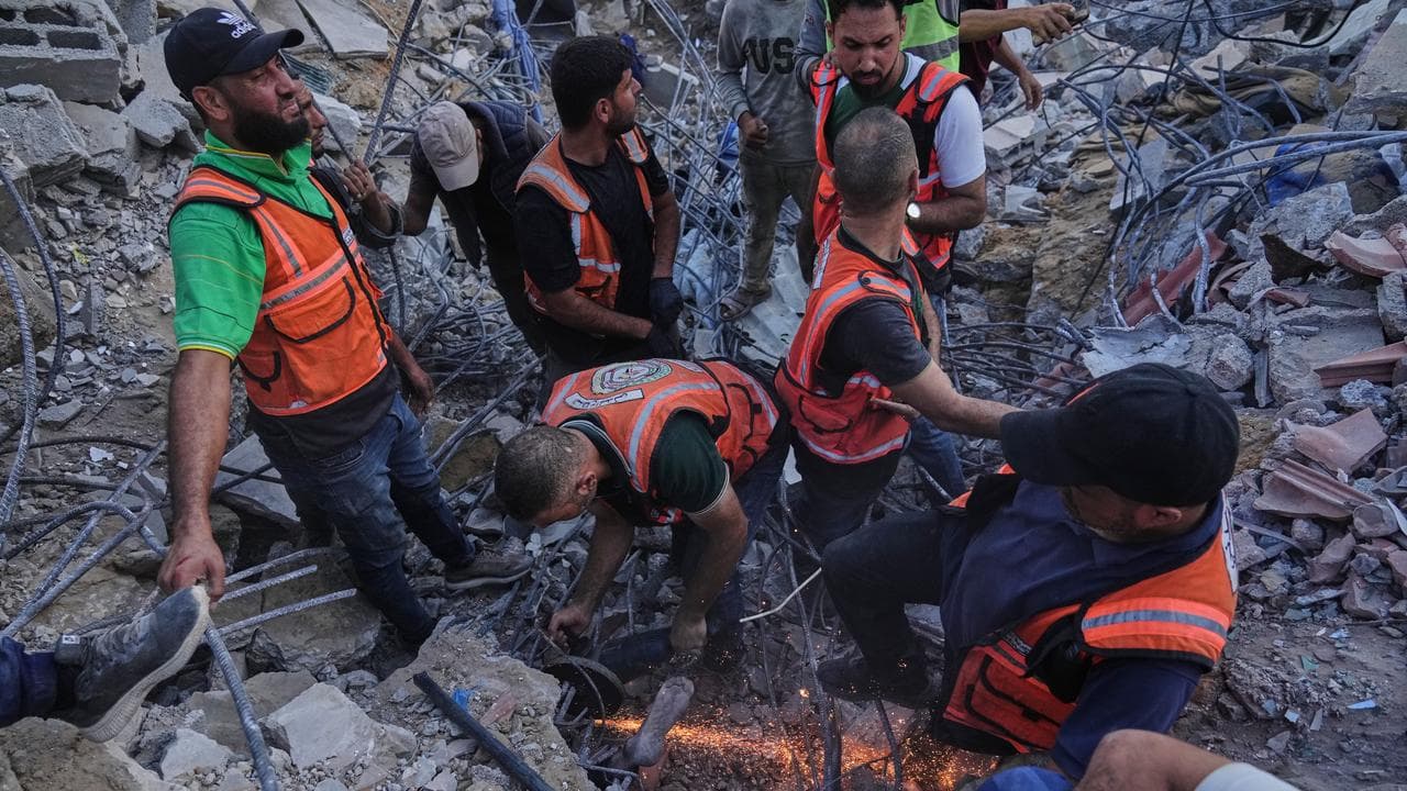 Crews search for bodies in the rubble of a collapsed building in Gaza