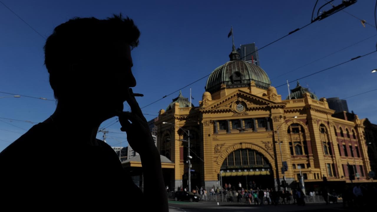 Stock image of a man smoking outside Flinders Station in Melbourne