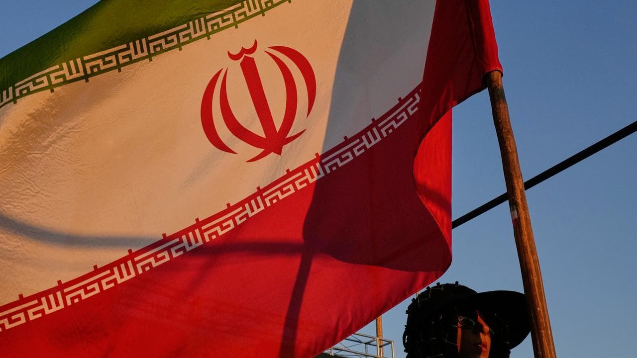 A woman holds an Iranian flag in Tehran