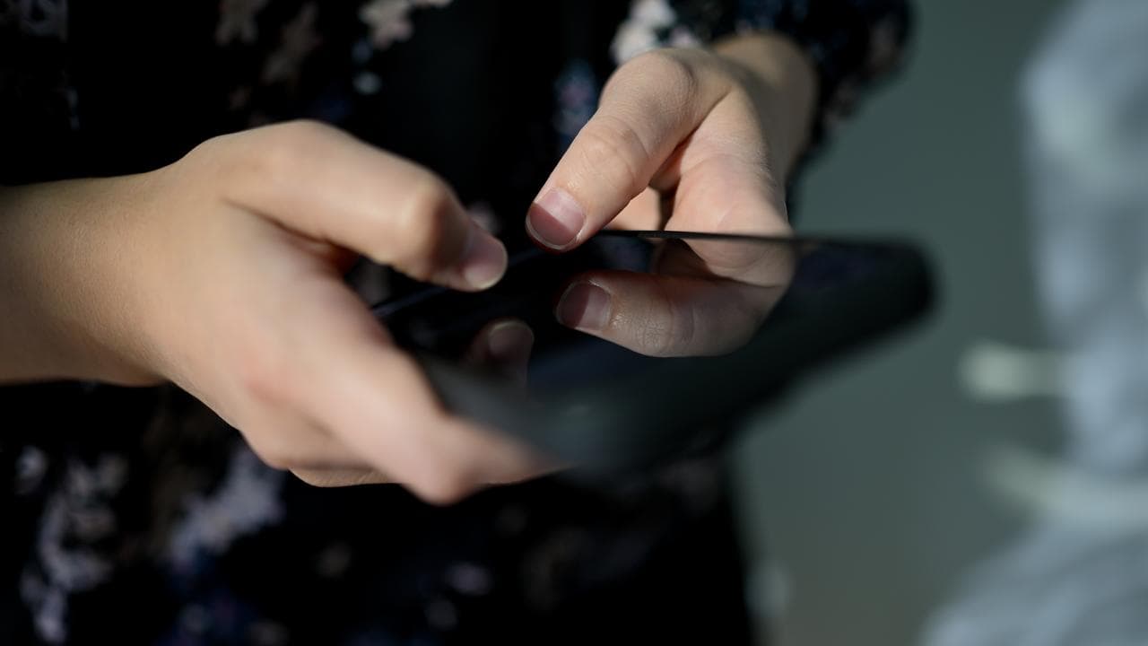A generic image of a person on their phone.
