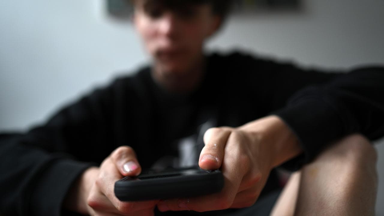 A teenager using his mobile phone.