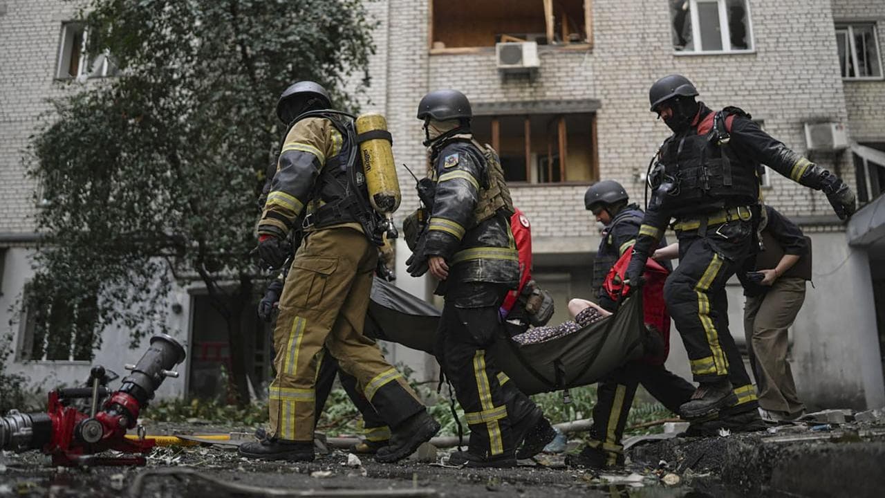 Rescuers carry an injured woman after a Russian attack on Kyiv