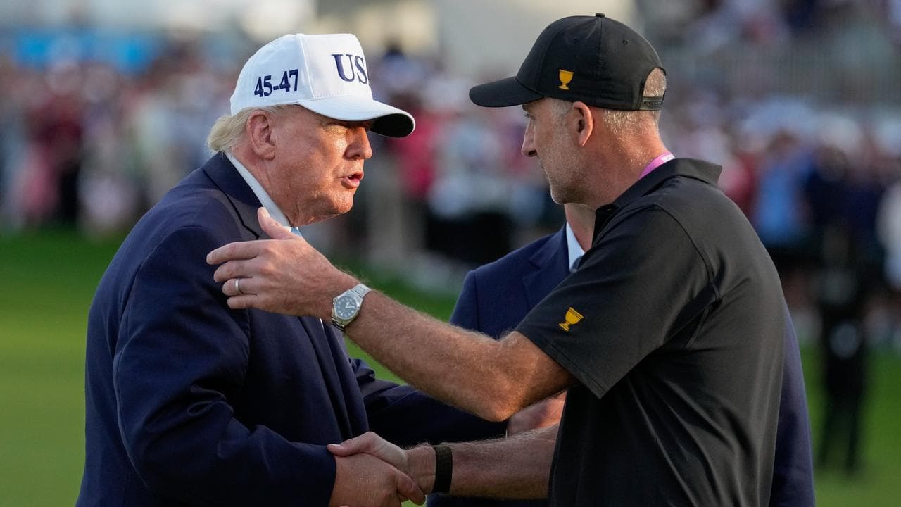Donald Trump greets International team captain Geoff Ogilvy.