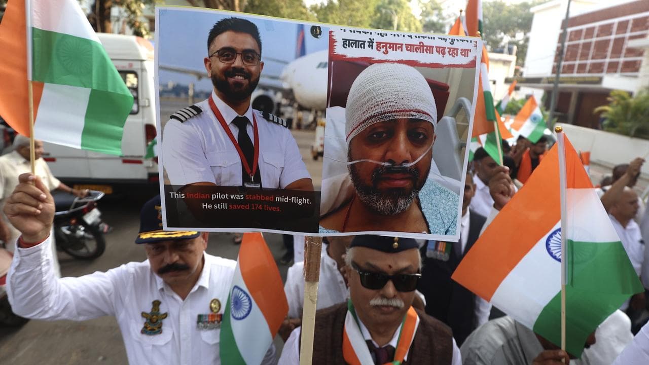 Participants hold photos depicting Indian pilot Smit Machchhar