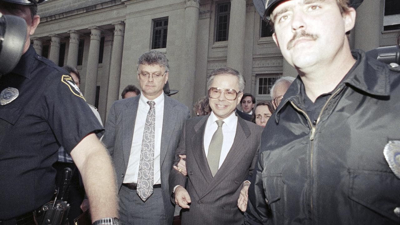 Jim Bakker leaves court with lawyers after a guilty verdict in 1989