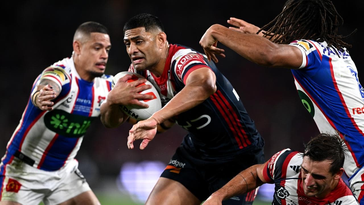 Daniel Tupou  evades Dane Gagai (left) and Dominic Young