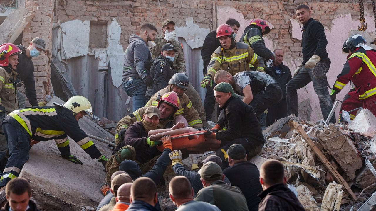 Rescuers carry an injured man after a Russian strike on Pryluky