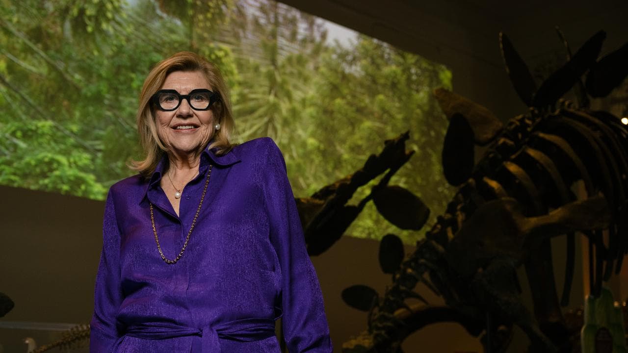 Kim McKay infront of a dinosaur skeleton